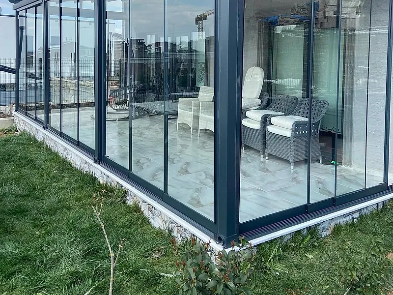 Teras üzerine kurulmuş antrasit profilli camlı yaşam alanı — cam balkon uygulaması